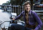 01-01-1978 Ramses Shaffy on location in Amsterdam.

[keywords]Boat, Canal, Half Length, Smiling[/keywords]